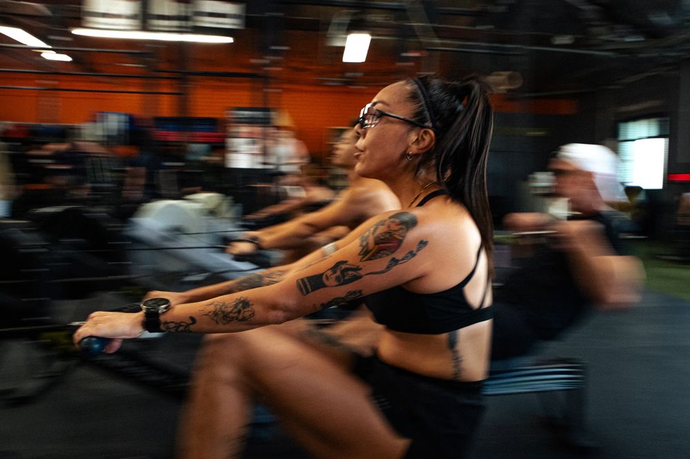 An athlete rowing hard during a drop-in class