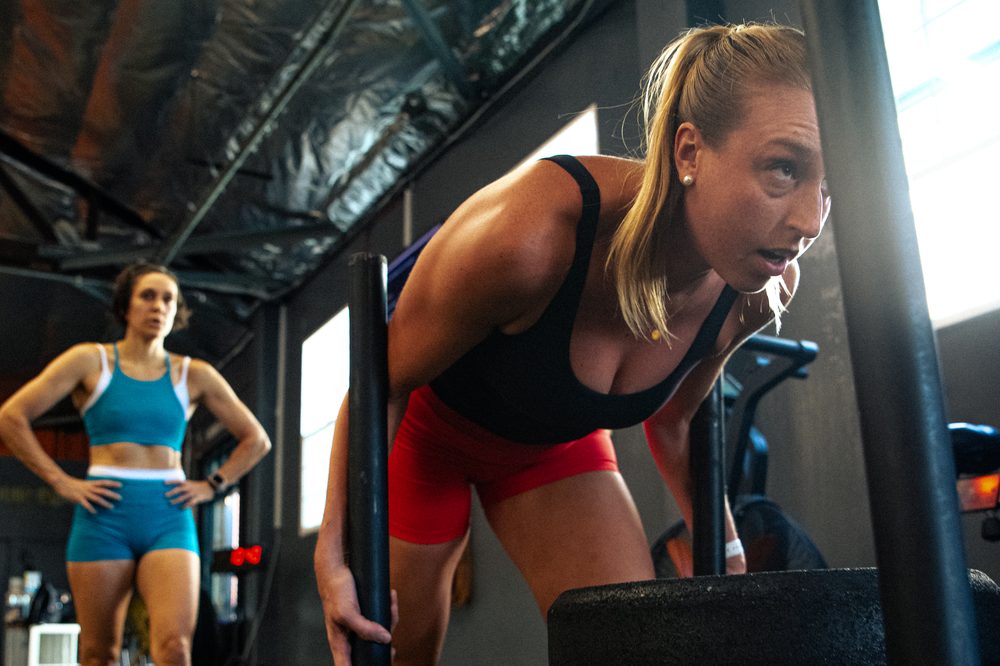 An athlete pushing a loaded sled in GSTRENGTH