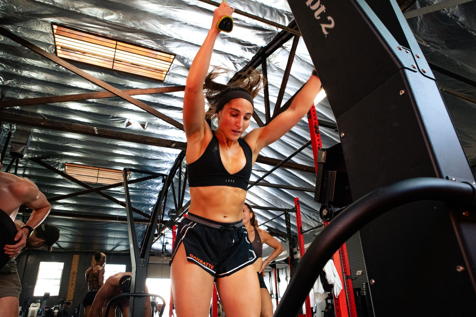 An athlete pulling hard on the SkiErg during a Ganbatte HYROX workout