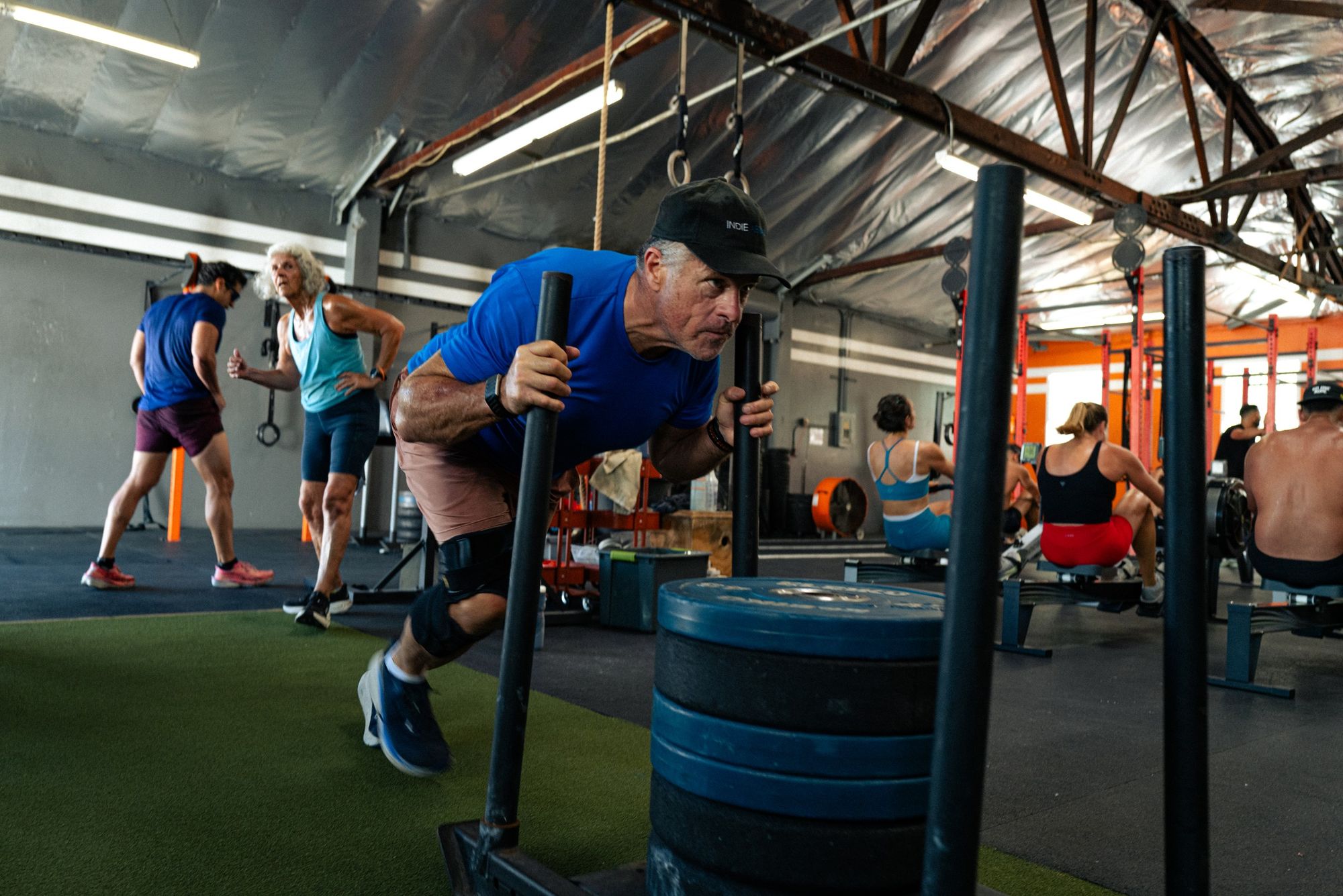 Athletes pushing sleds across the Ganbatte gym